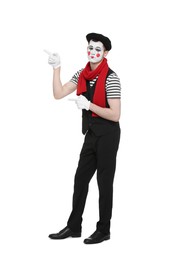 Funny mime artist in beret pointing at something on white background