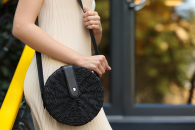 Photo of Young woman with stylish handbag outdoors on summer day, closeup