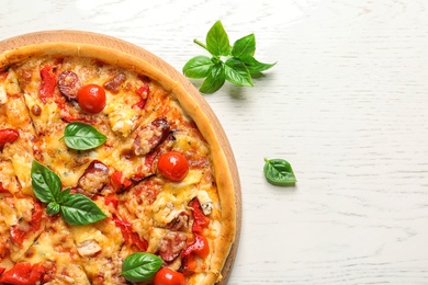 Delicious pizza with tomatoes and sausages on table, top view