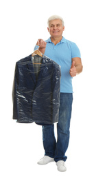 Photo of Senior man holding hanger with jacket in plastic bag on white background. Dry-cleaning service