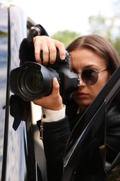 Photo of Private detective with camera spying near car outdoors