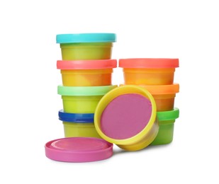 Plastic containers with colorful play dough on white background