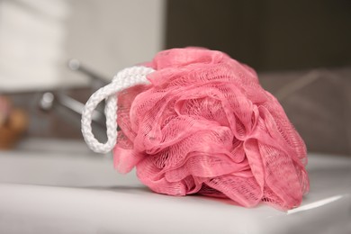 Pink shower puff on washbasin in bathroom, closeup