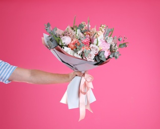 Man holding beautiful flower bouquet on pink background, closeup. Space for text
