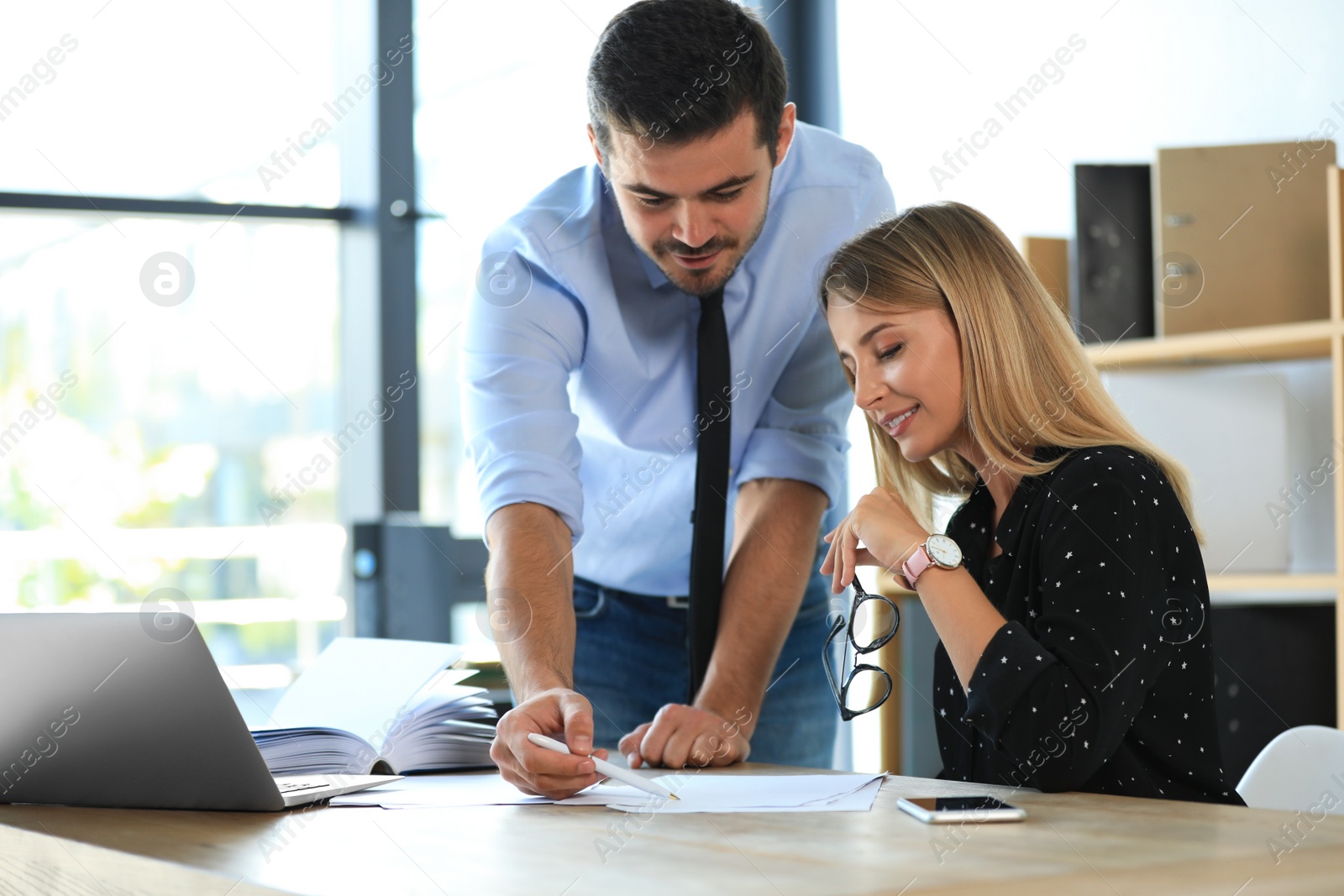 Photo of Male business trainer coaching young woman in office