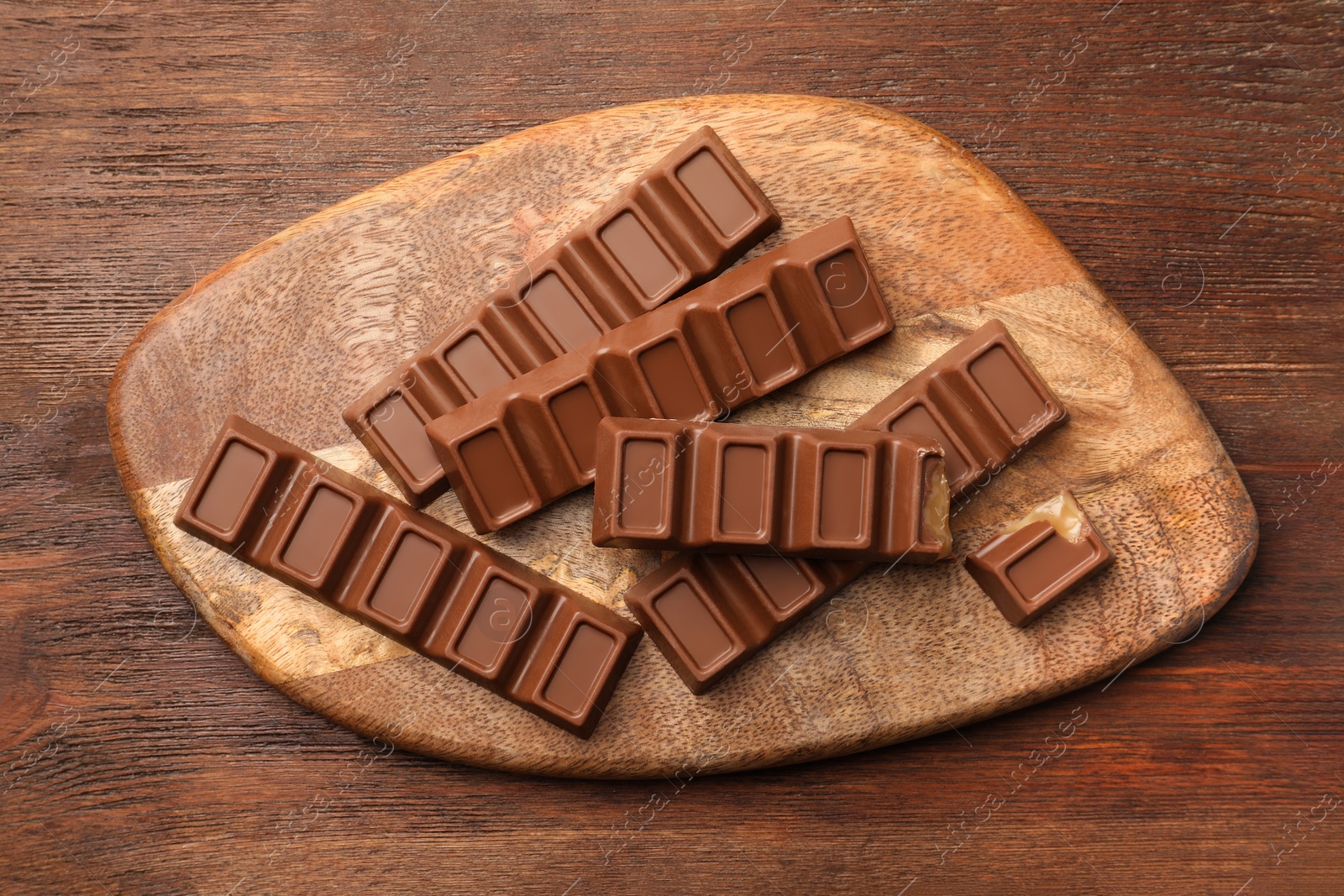 Photo of Tasty chocolate bars on wooden table, top view