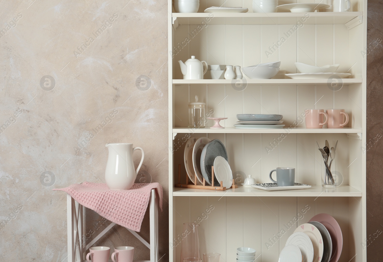 Photo of Stylish storage stand with different ceramic dishware at home