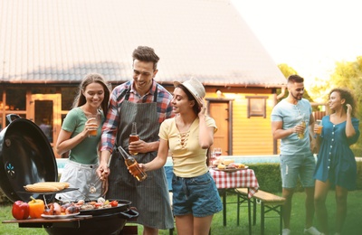 Group of friends having fun at barbecue party outdoors