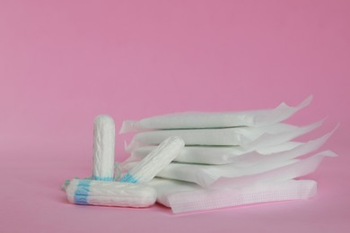 Photo of Menstrual pads and tampons on pink background