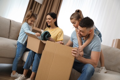 Photo of Happy family unpacking moving boxes at their new house