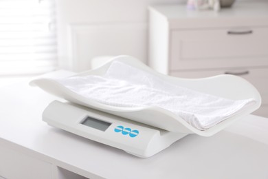 Modern digital baby scales on table in room