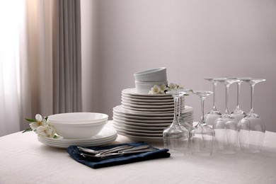 Set of clean dishware, cutlery and wine glasses on table indoors