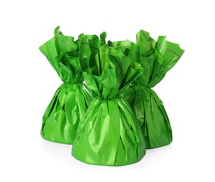 Photo of Delicious candies in green wrappers on white background