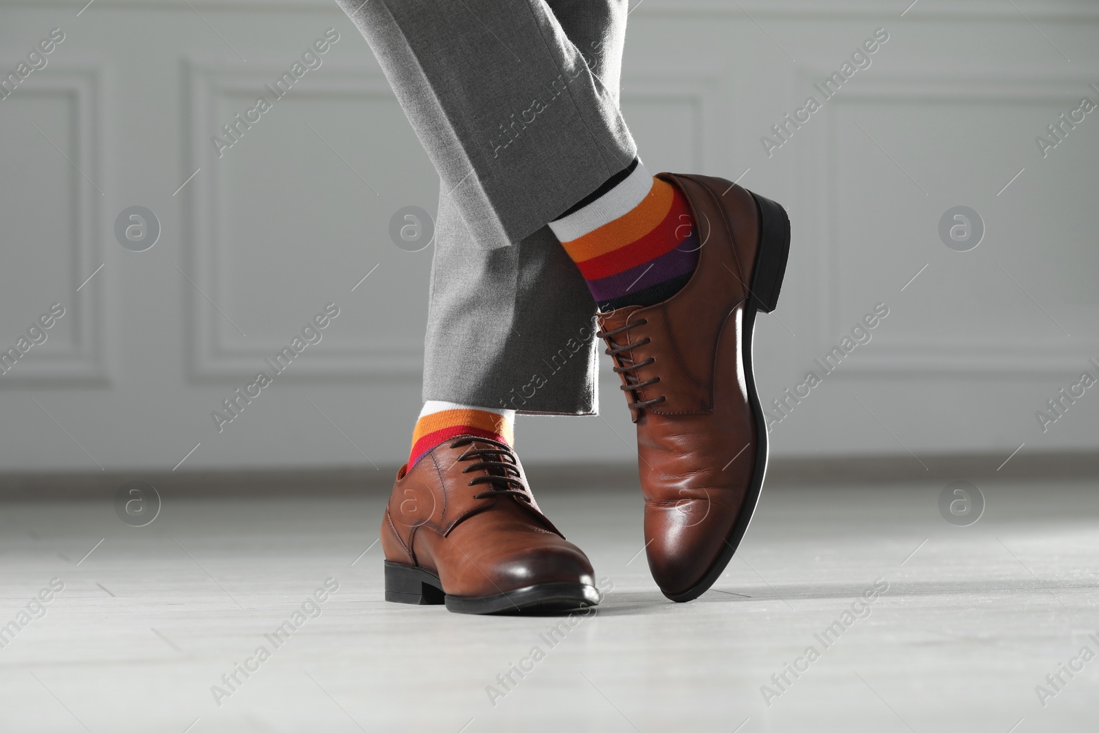 Photo of Man wearing stylish shoes and colorful socks indoors, closeup