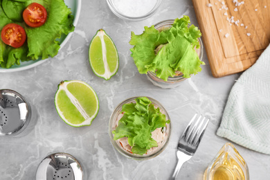 Photo of Healthy salad in glass jars on marble table, flat lay