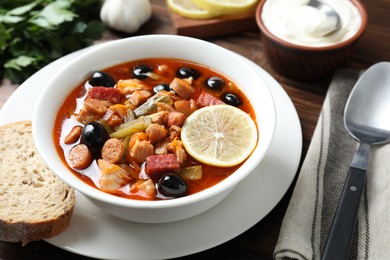 Meat solyanka soup with sausages, olives and vegetables served on table, closeup