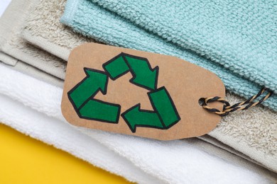 Photo of Stacked towels with recycling label, closeup view