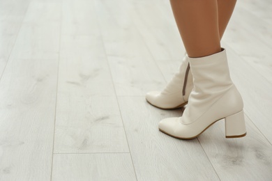 Photo of Woman wearing stylish leather shoes indoors, closeup. Space for text