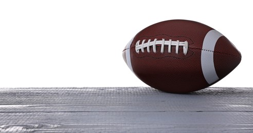 Photo of American football ball on grey wooden table against white background. Space for text
