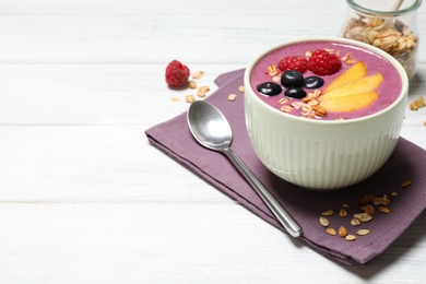 Photo of Delicious acai smoothie with fruits served on white wooden table. Space for text