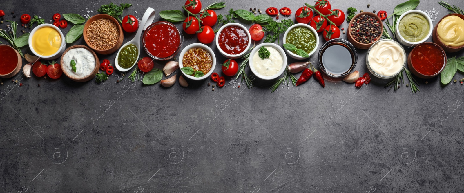 Photo of Flat lay composition with different sauces and space for text on gray background