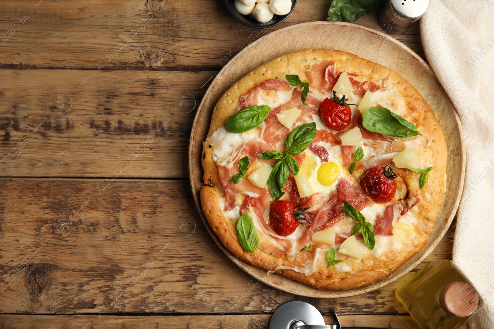 Photo of Pita pizza with prosciutto, pineapple, grilled tomatoes and egg on wooden table, flat lay. Space for text