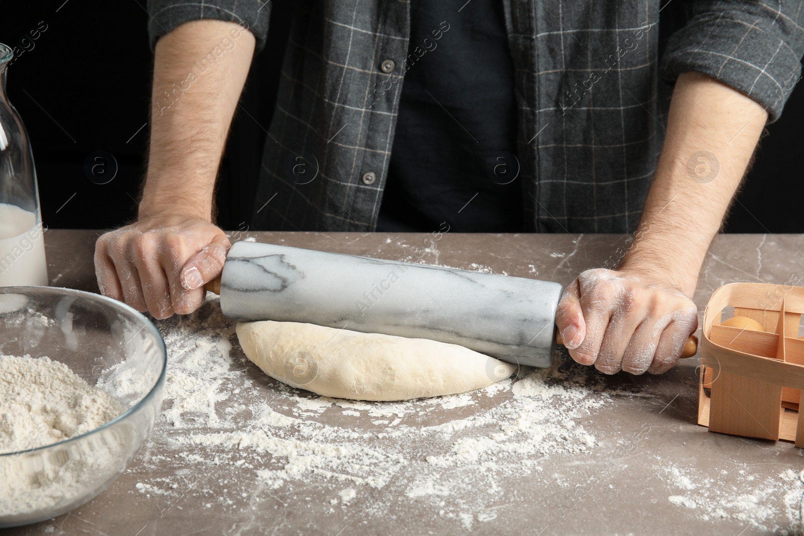 Photo of Man rolling dough for pizza on table