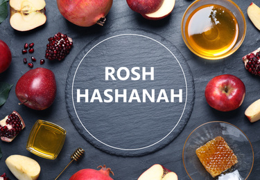 Frame of honey, apples and pomegranates on black table, flat lay. Rosh Hashanah holiday