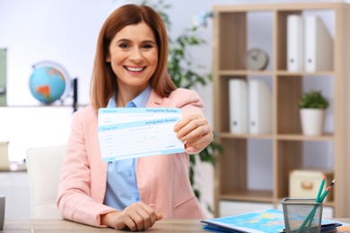 Photo of Beautiful consultant holding tickets in travel agency