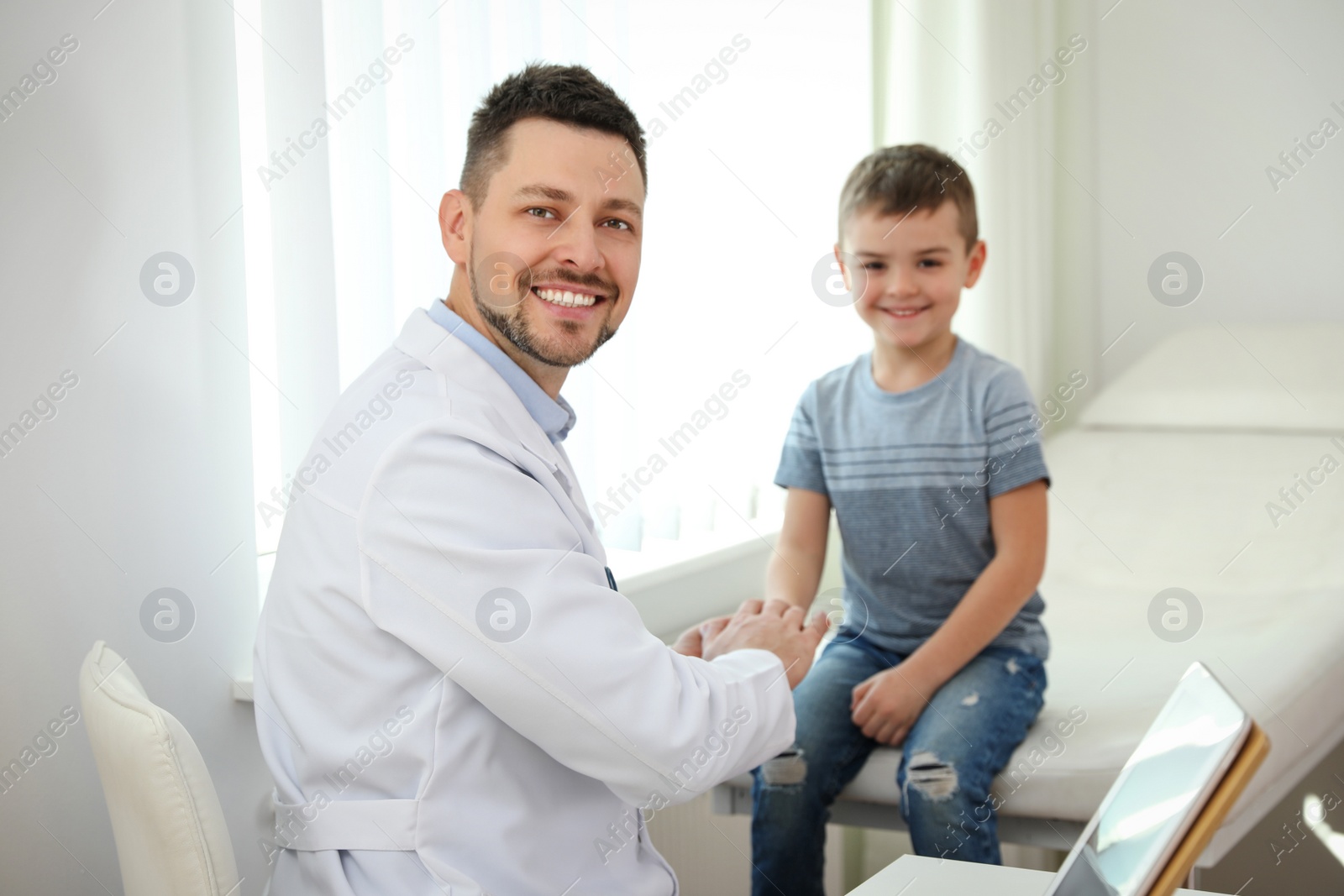 Photo of Children's doctor working with little patient in clinic