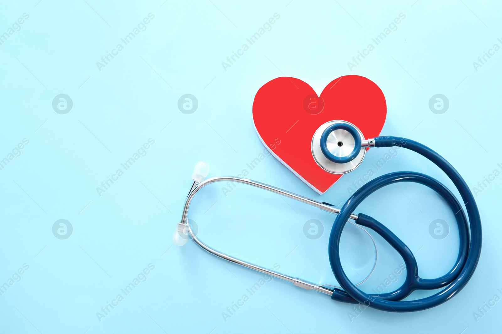 Photo of Flat lay composition with red heart and stethoscope on color background, top view