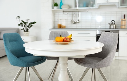 Stylish room interior with dining table and chairs