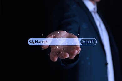 Image of Real estate agent holding virtual search bar with word House on black background, closeup