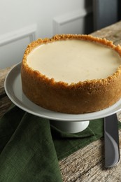 Photo of Tasty vegan tofu cheesecake and knife on wooden table