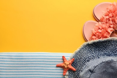 Flat lay composition with beach accessories on yellow background, space for text