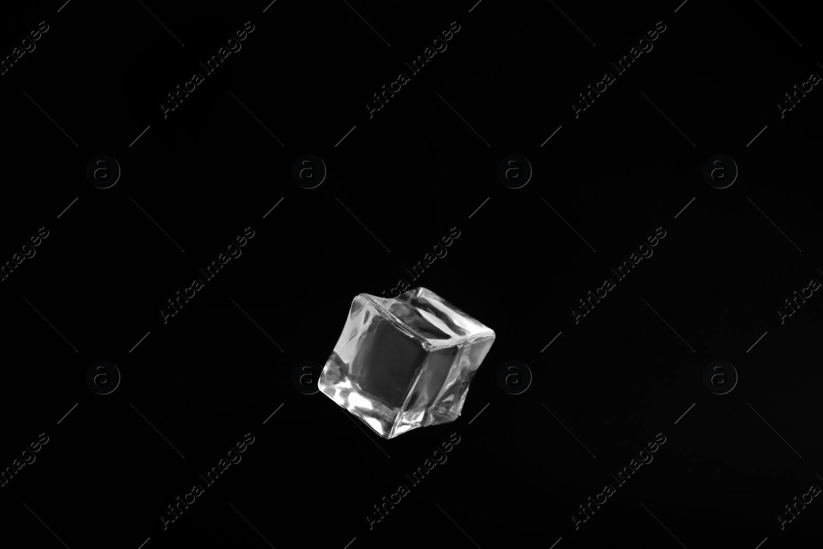Photo of Crystal clear ice cube on black background
