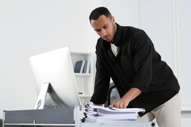 Photo of Man working with documents at grey table in office