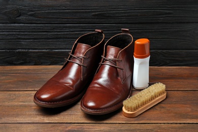 Leather footwear and shoe shine kit on wooden surface