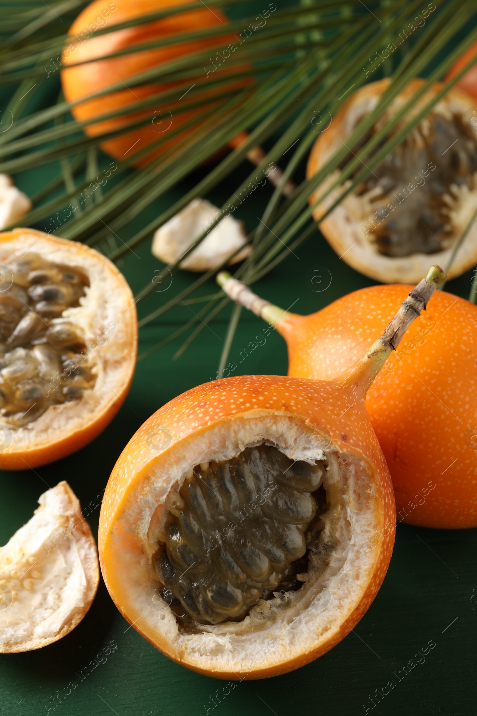 Photo of Delicious ripe granadillas on green wooden table