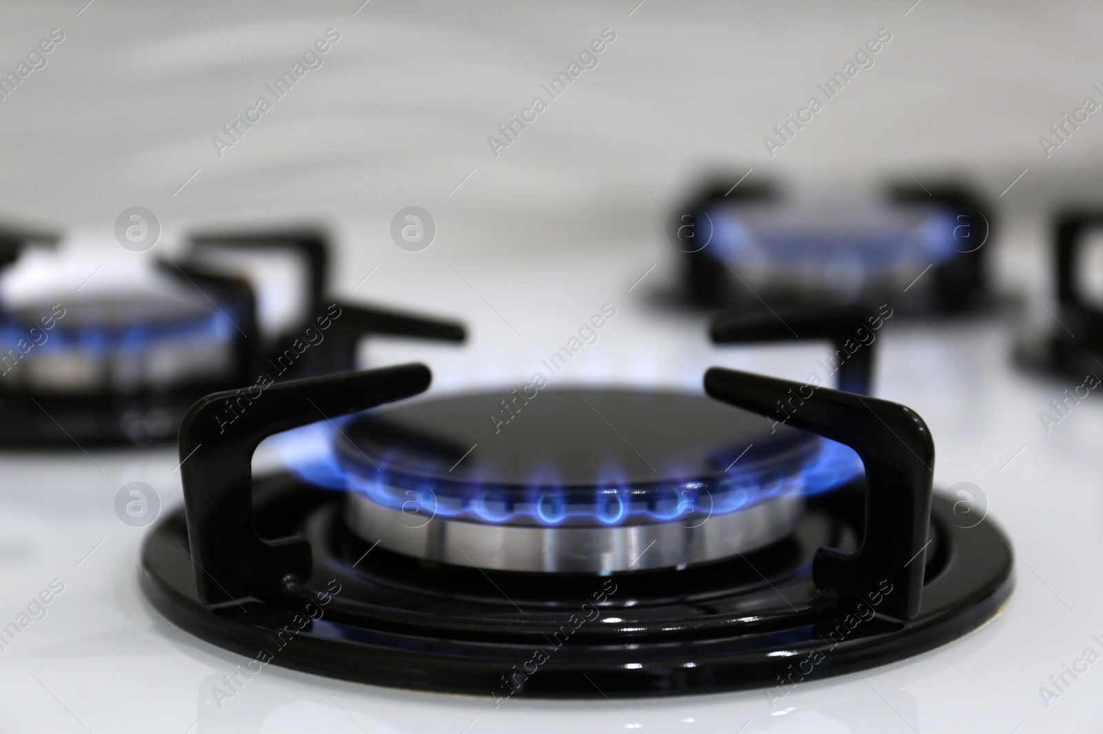 Photo of Modern kitchen stove with burning gas, closeup