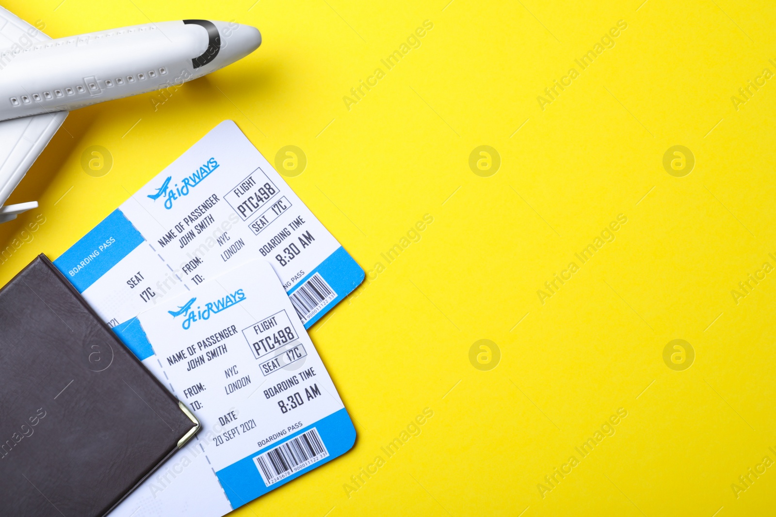 Photo of Toy airplane, passport and tickets on yellow background, flat lay with space for text. Travel agency concept