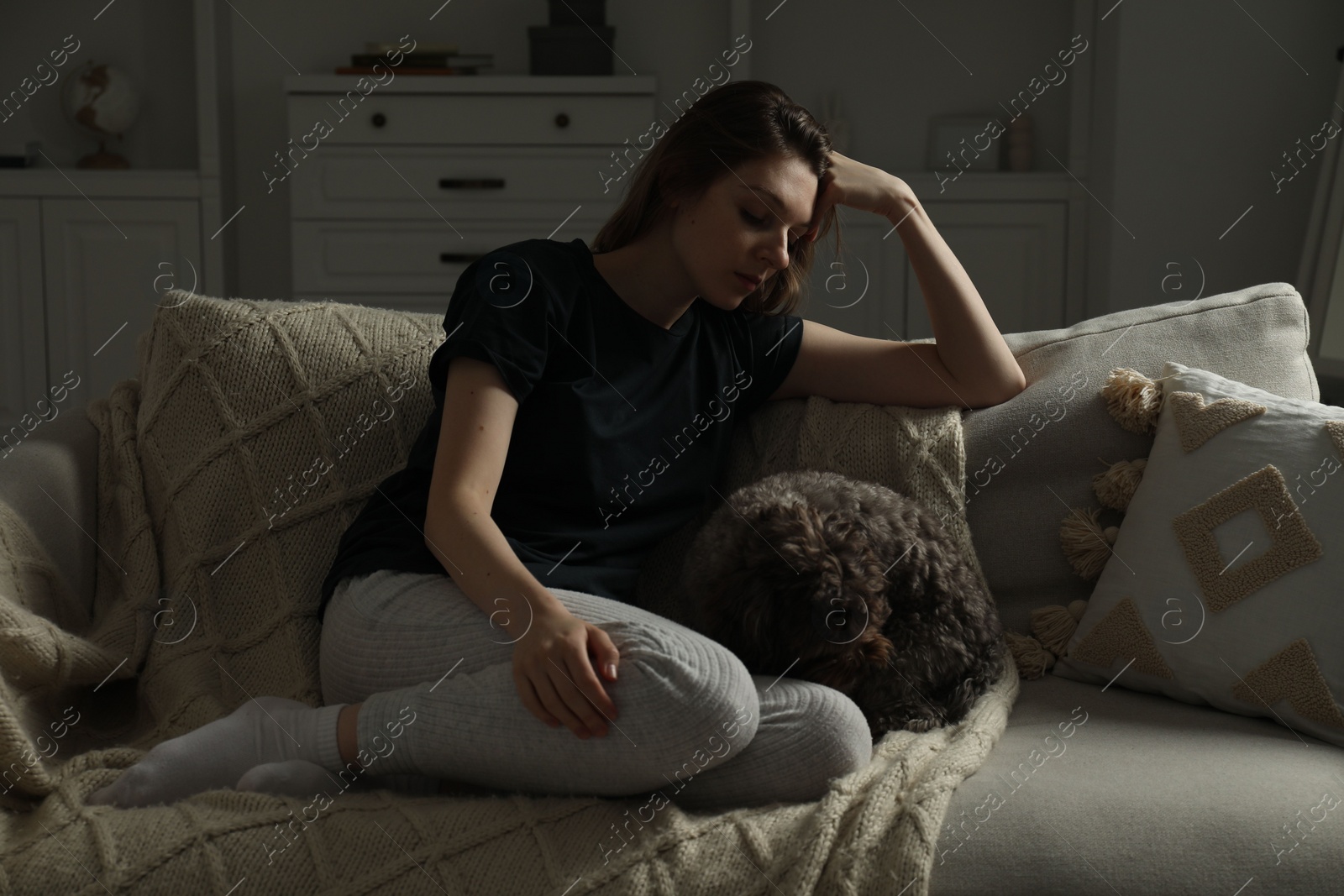 Photo of Sad young woman and her dog on sofa at home