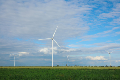 Photo of Beautiful view of field with wind turbines. Alternative energy source