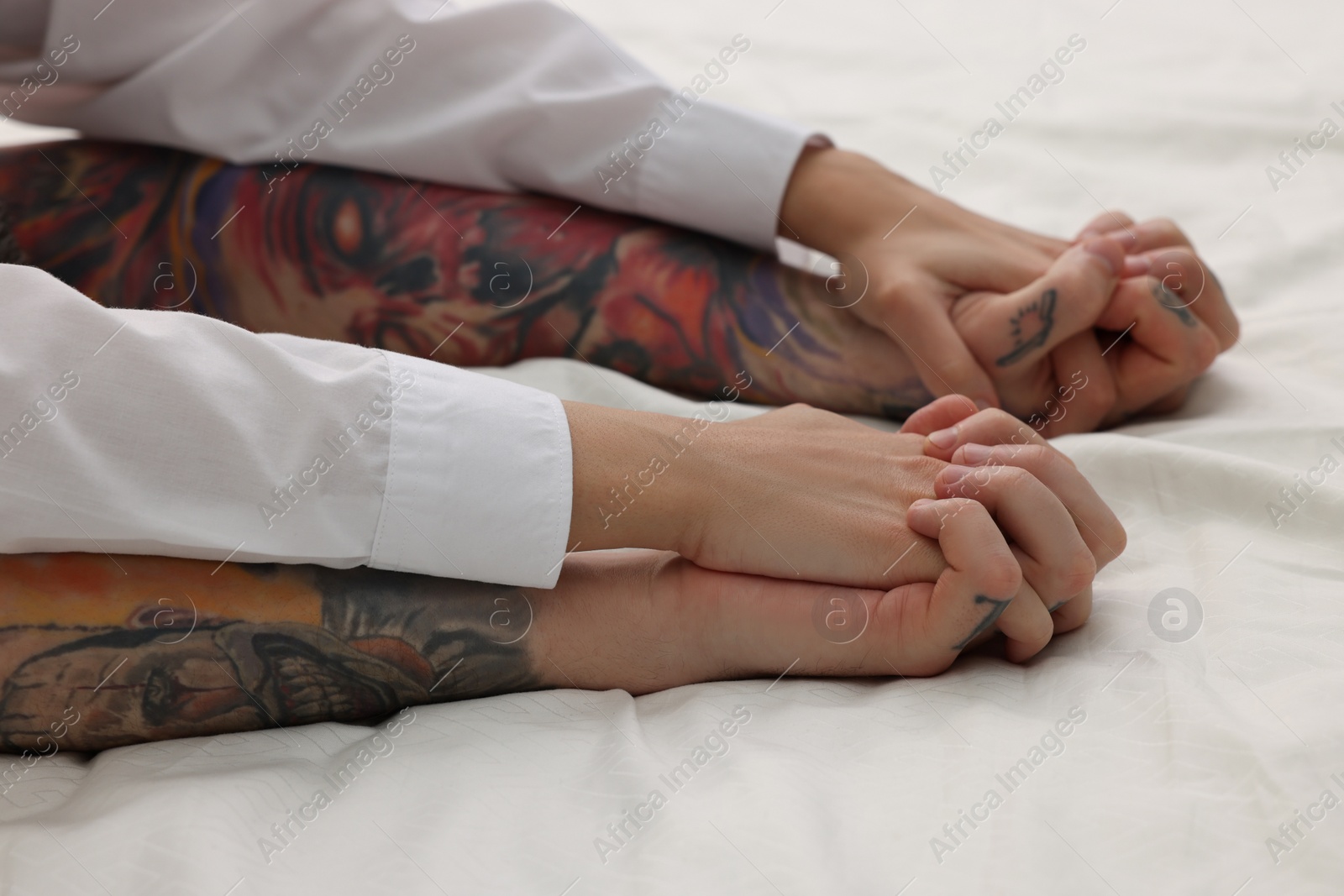 Photo of Passionate couple having sex on bed, closeup of hands