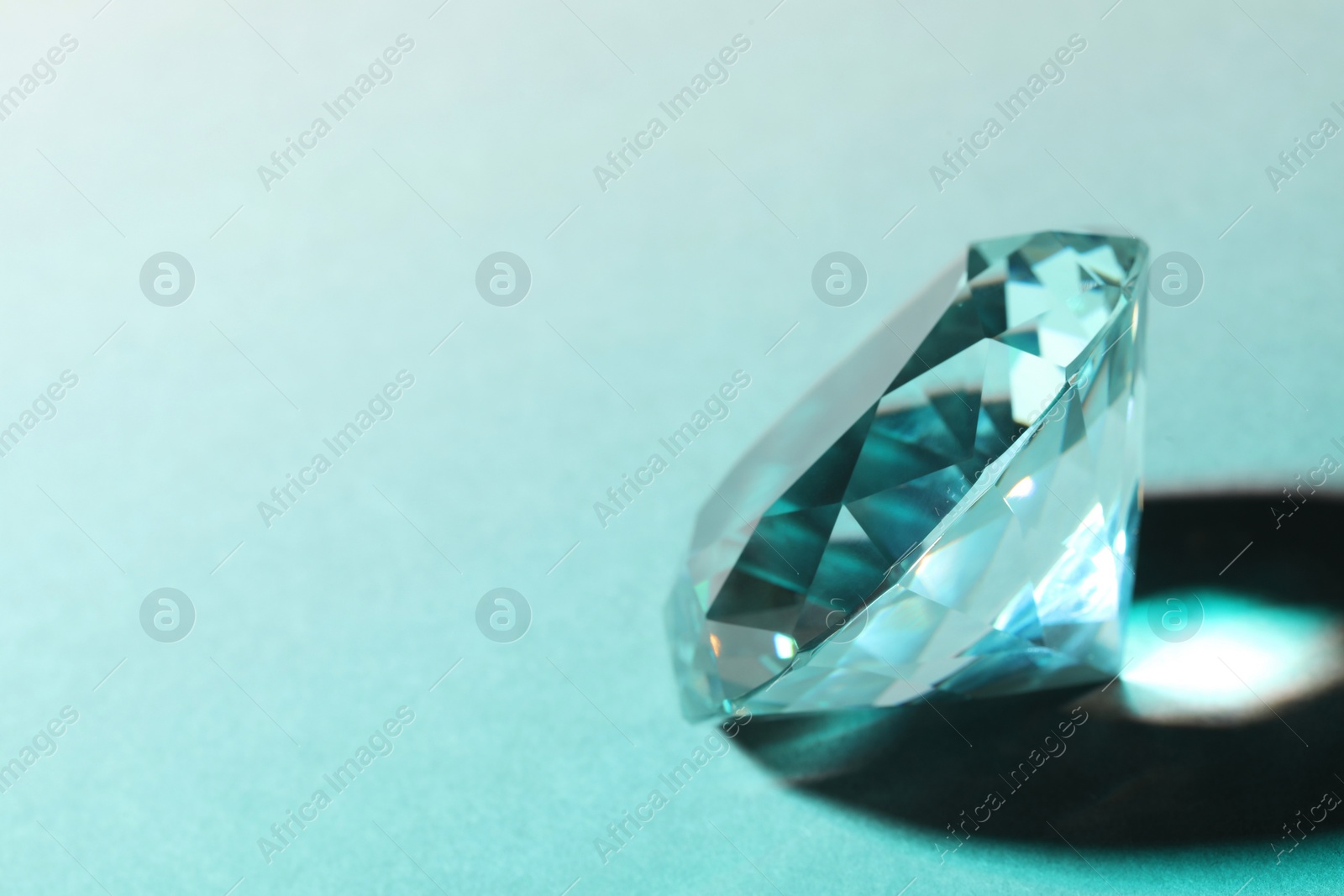 Photo of Beautiful dazzling diamond on light background, closeup. Space for text