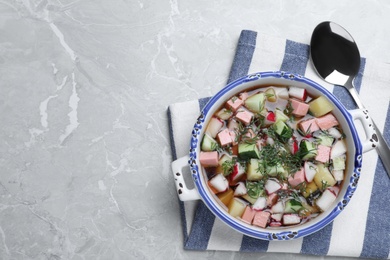 Photo of Delicious cold okroshka with kvass served on grey table, flat lay and space for text. Traditional Russian summer soup