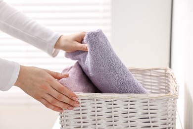 Woman with laundry basket of clean towels indoors, closeup