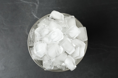 Photo of Metal bucket with ice cubes on grey background, top view