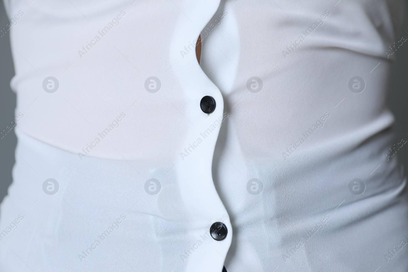 Photo of Overweight woman in tight shirt on grey background, closeup