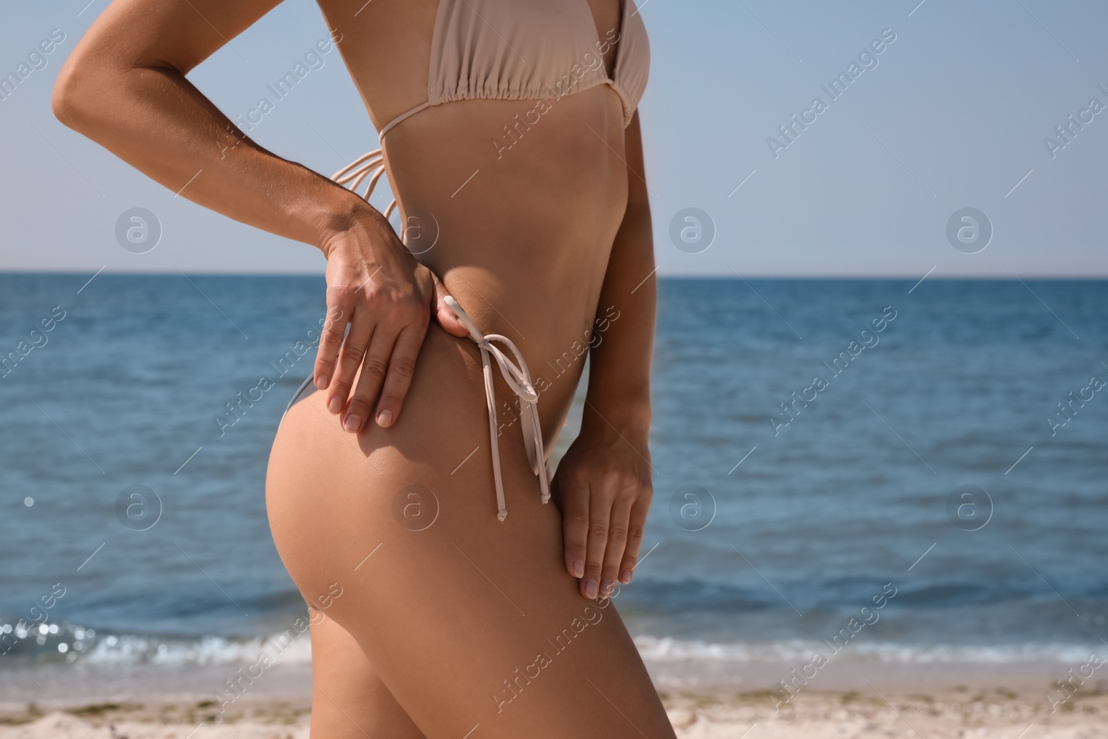 Photo of Woman with perfect body in bikini near sea, closeup